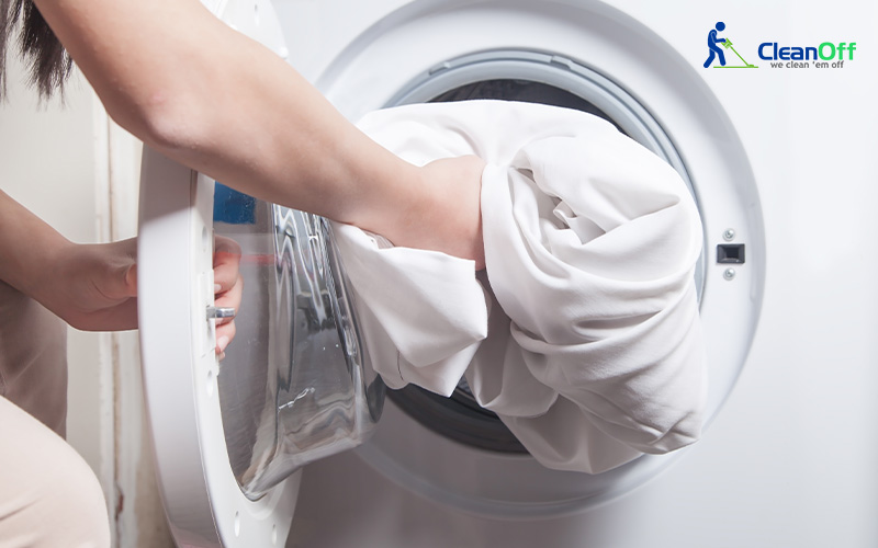 a woman doing fabrics care by putting them in washing machine