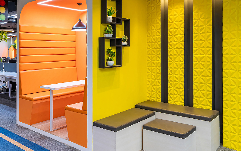 Vibrant orange and yellow office breakout booth with seating.